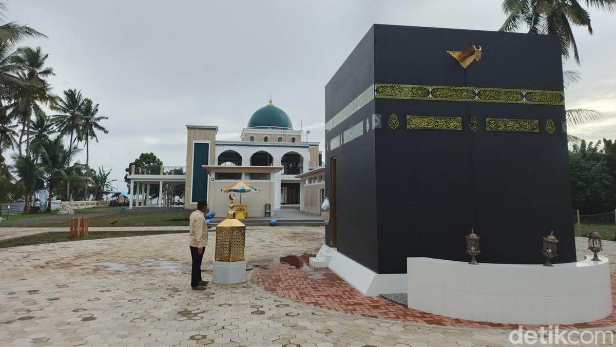 Kubah hijau masjid berlatar miniatur Ka'bah di pelataran manasik.